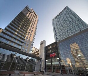 A modern high-rise building with a casino sign, surrounded by other tall buildings. - Platinum Towers Country 2 Country (Warsaw)