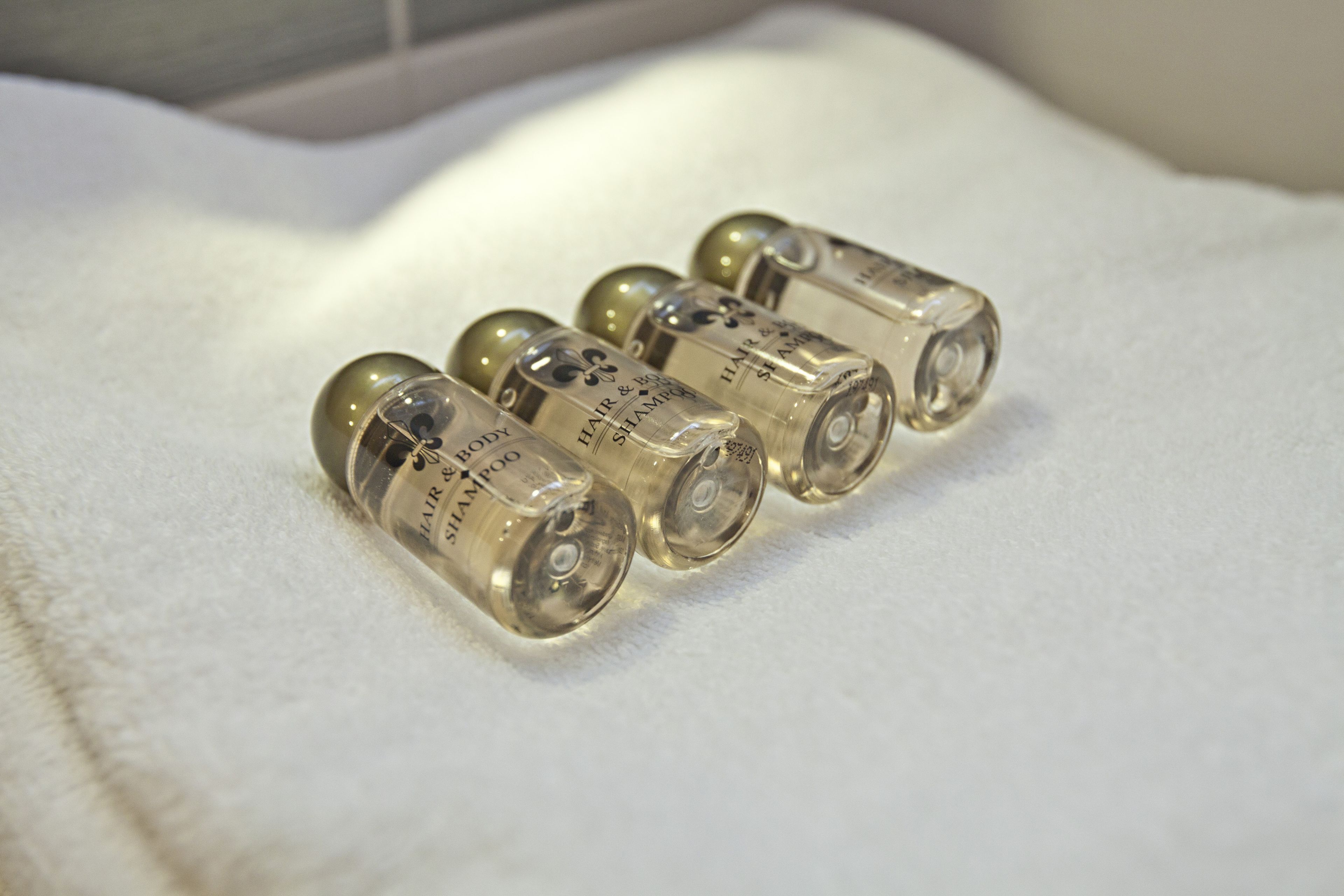 Four clear glass bottles with labels on a white surface.
