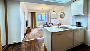 A modern kitchen with a skylight, a dining area with a sofa, and a view of the city through large windows. - Platinum Towers Country 2 Country (Warsaw)