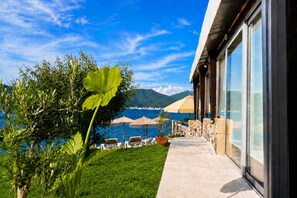 A coastal property with a stone pathway leading to outdoor seating, overlooking the sea and mountains. - Sea Residence Kristina Romantica (Gosici)