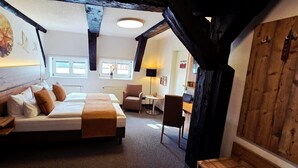 A bedroom with a bed, bedside tables, a desk, and a chair.
