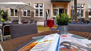 An outdoor seating area with tables, chairs, and umbrellas.