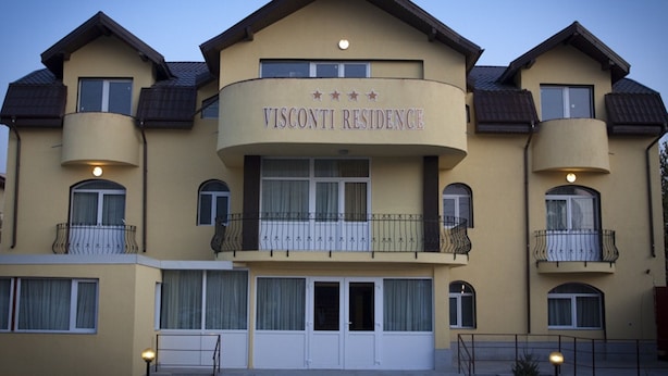 A multi-story building with a curved facade, balconies with metal railings, and a sign reading "VISCONTI RESIDENCE". - Visconti Residence (Bucharest)