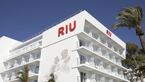 Un edificio moderno con el nombre "RIU" visible en su fachada.