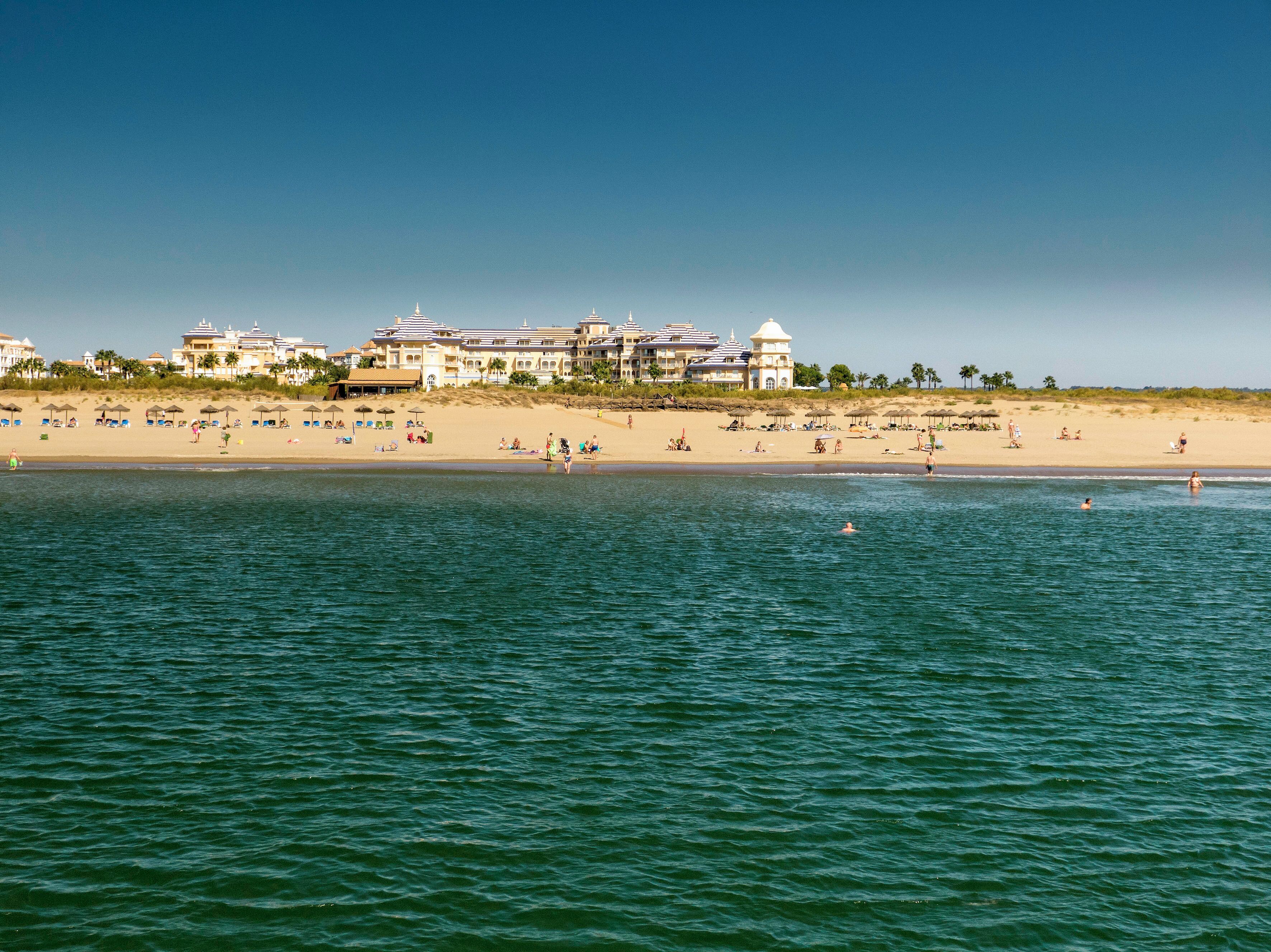 A beach resort with multiple buildings, a sandy beach, and the ocean.