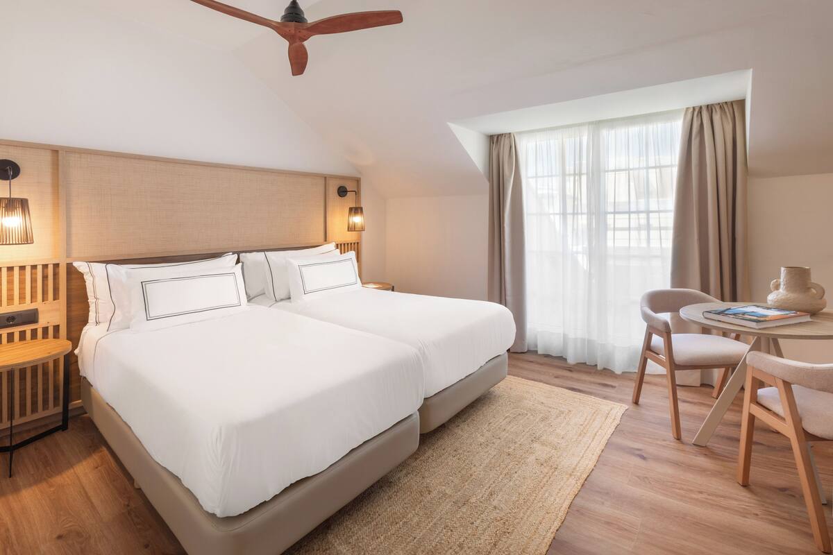 Une chambre d’hôtel avec un grand lit, un bureau et une chaise.