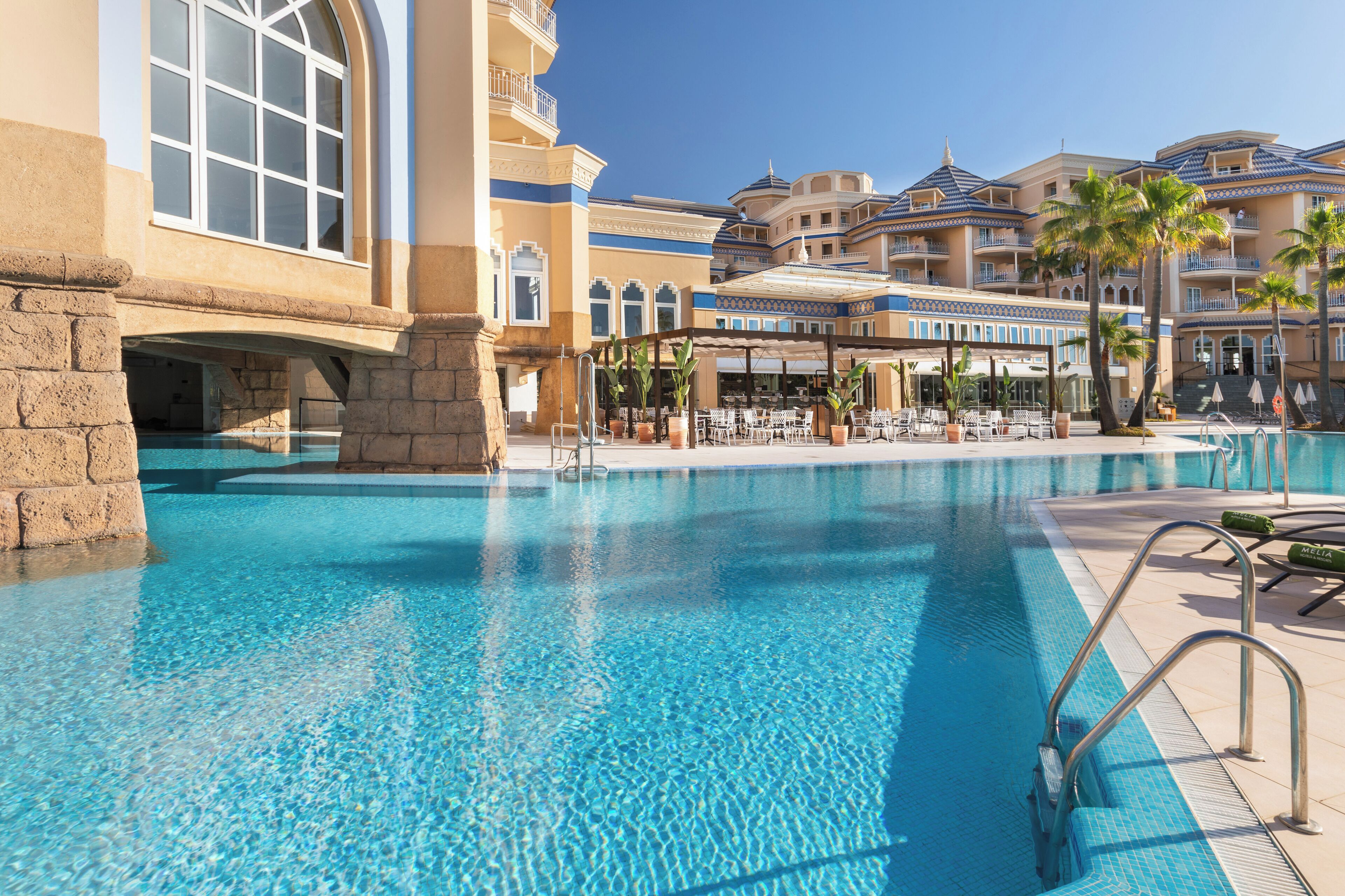 Een binnenzwembad, een buitenzwembad en parasols bij het zwembad