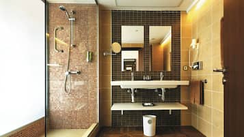 A modern bathroom with a glass shower enclosure, a sink with a mirror, and a toilet.