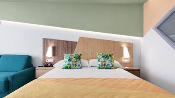 A hotel room with a bed, two pillows, a bedside table with a lamp, a nightstand, and a teal armchair.