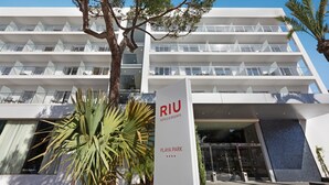 En moderne hotelbygning med flere balkoner og et skilt, der angiver, at det er Riu Hotels & Resorts Playa Park.