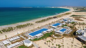 A resort with multiple swimming pools, beach access, and palm trees. - Hotel Riu Karamboa - Adults Only - All Inclusive (Boa Vista)