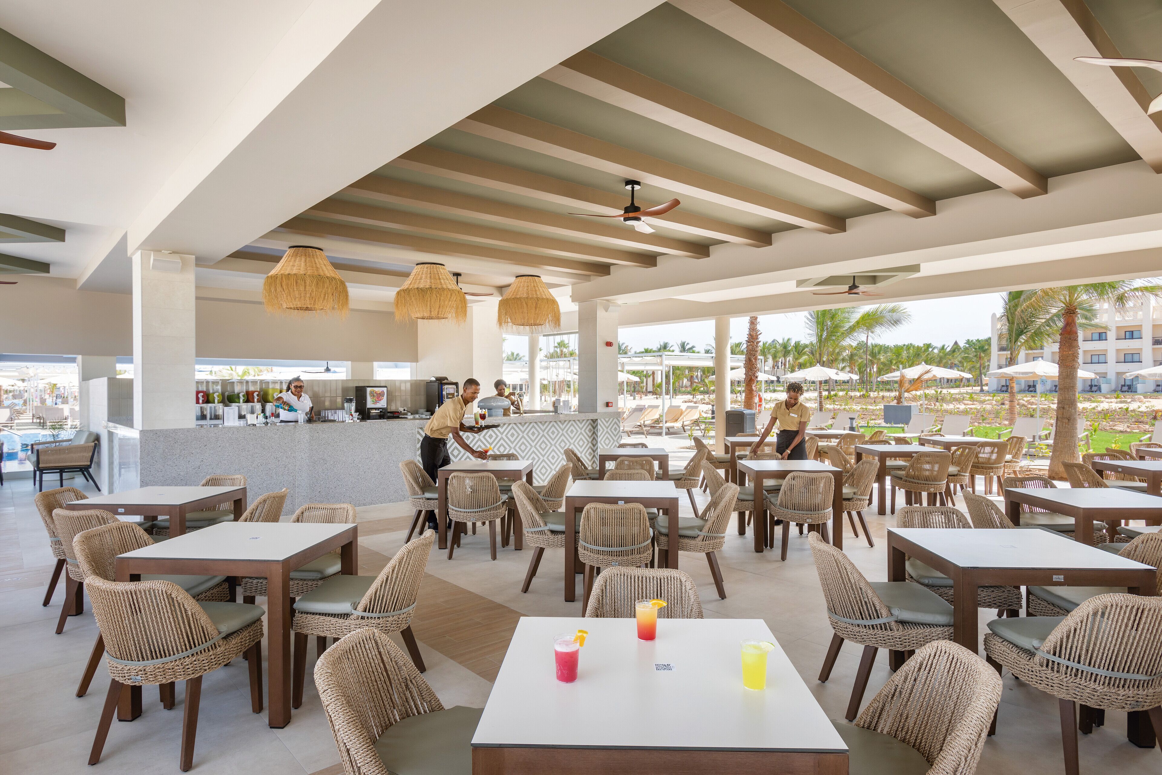 Un restaurante con mobiliario de mimbre y una zona de bar.