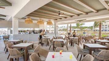 Un restaurante con mobiliario de mimbre y una zona de bar.