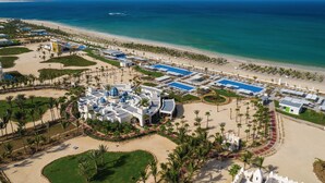 An aerial view of a resort with a beach, pool area, and palm trees. - Hotel Riu Karamboa - Adults Only - All Inclusive (Boa Vista)