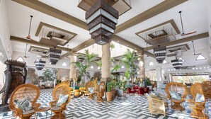 A spacious lobby with wicker furniture, a patterned floor, and a ceiling with hanging lights and fans. - Hotel Riu Karamboa - Adults Only - All Inclusive (Boa Vista)