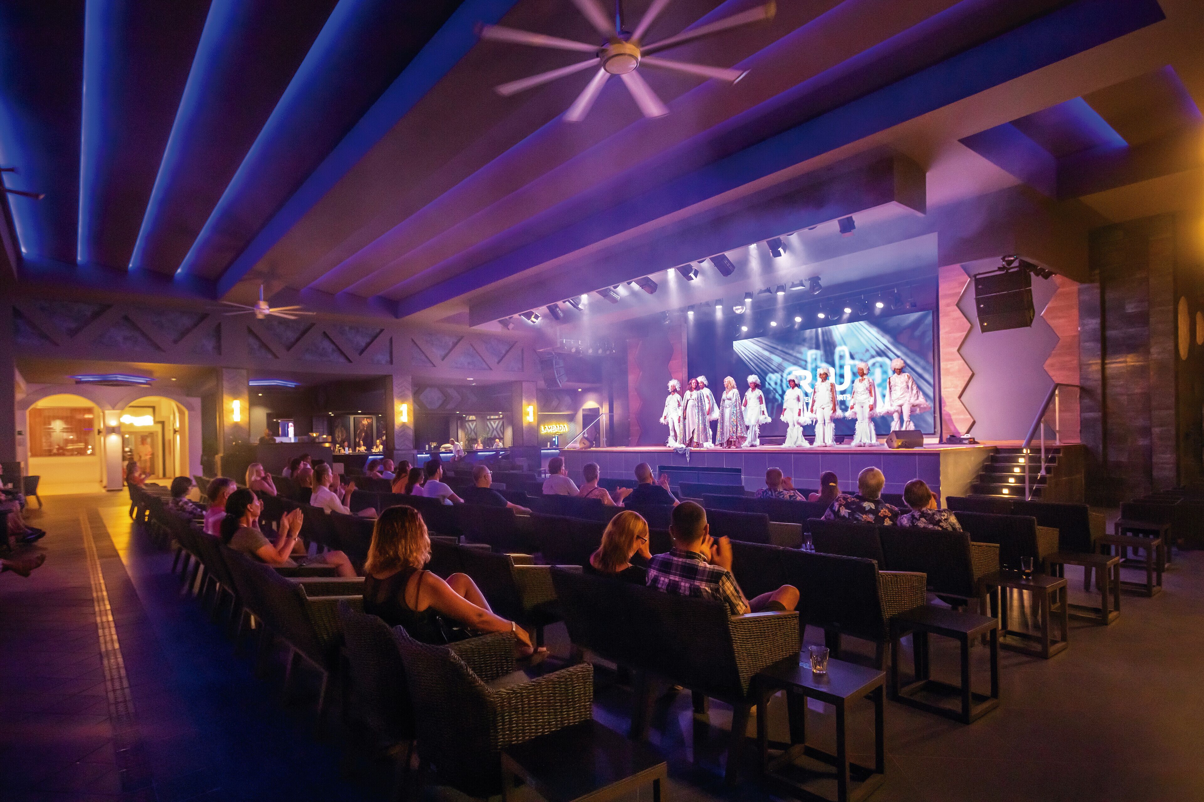 An indoor theater with rows of seating facing a stage.