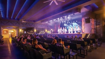 An indoor theater with rows of seating facing a stage.