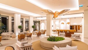 A spacious lobby with modern furniture, a central seating area, and a reception desk. - 3HB Guarana (Albufeira)