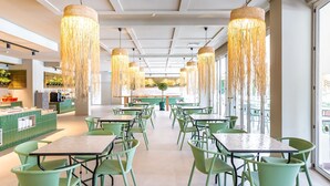 A restaurant with green chairs and tables, hanging light fixtures, and a counter with a green tiled backsplash. - 3HB Guarana (Albufeira)
