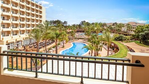 A hotel with a pool area, palm trees, and a view of the surrounding landscape. - 3HB Guarana (Albufeira)