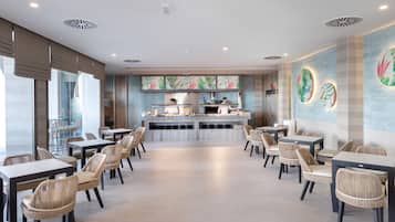 Un restaurant moderne avec un comptoir central, des chaises en osier et une vue sur la rue.