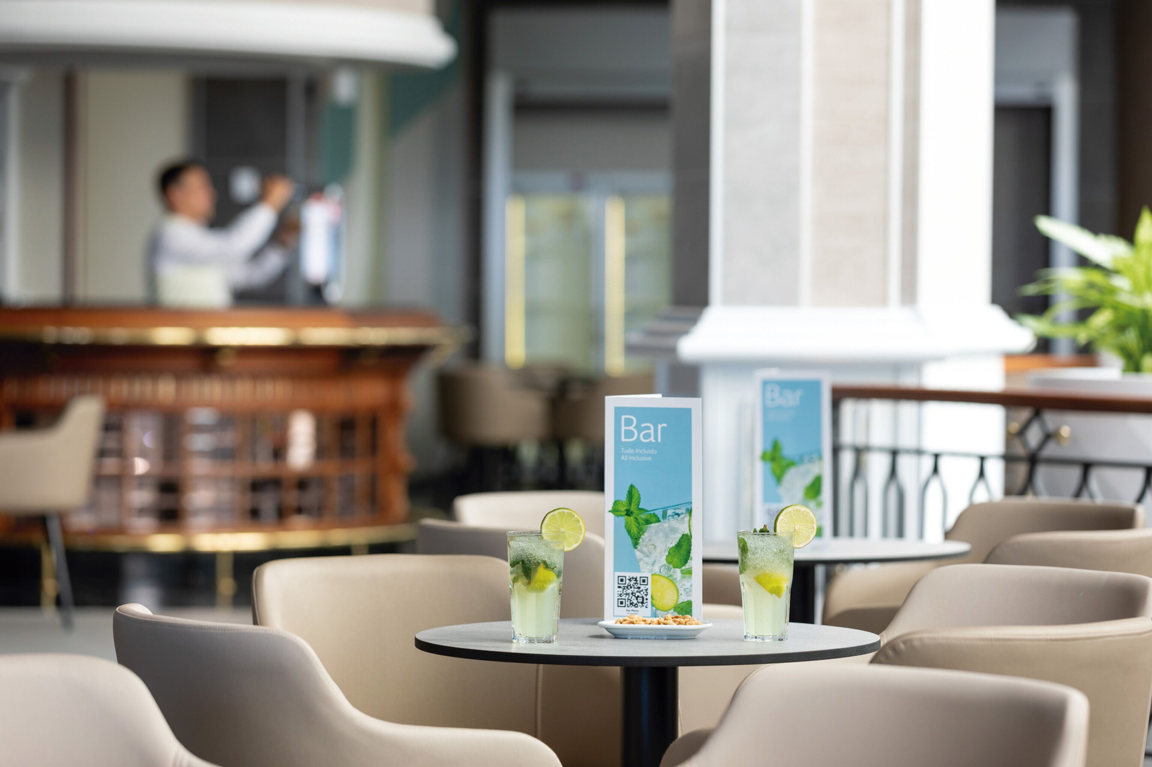 A bar area with two tables, each with a drink and a menu stand.