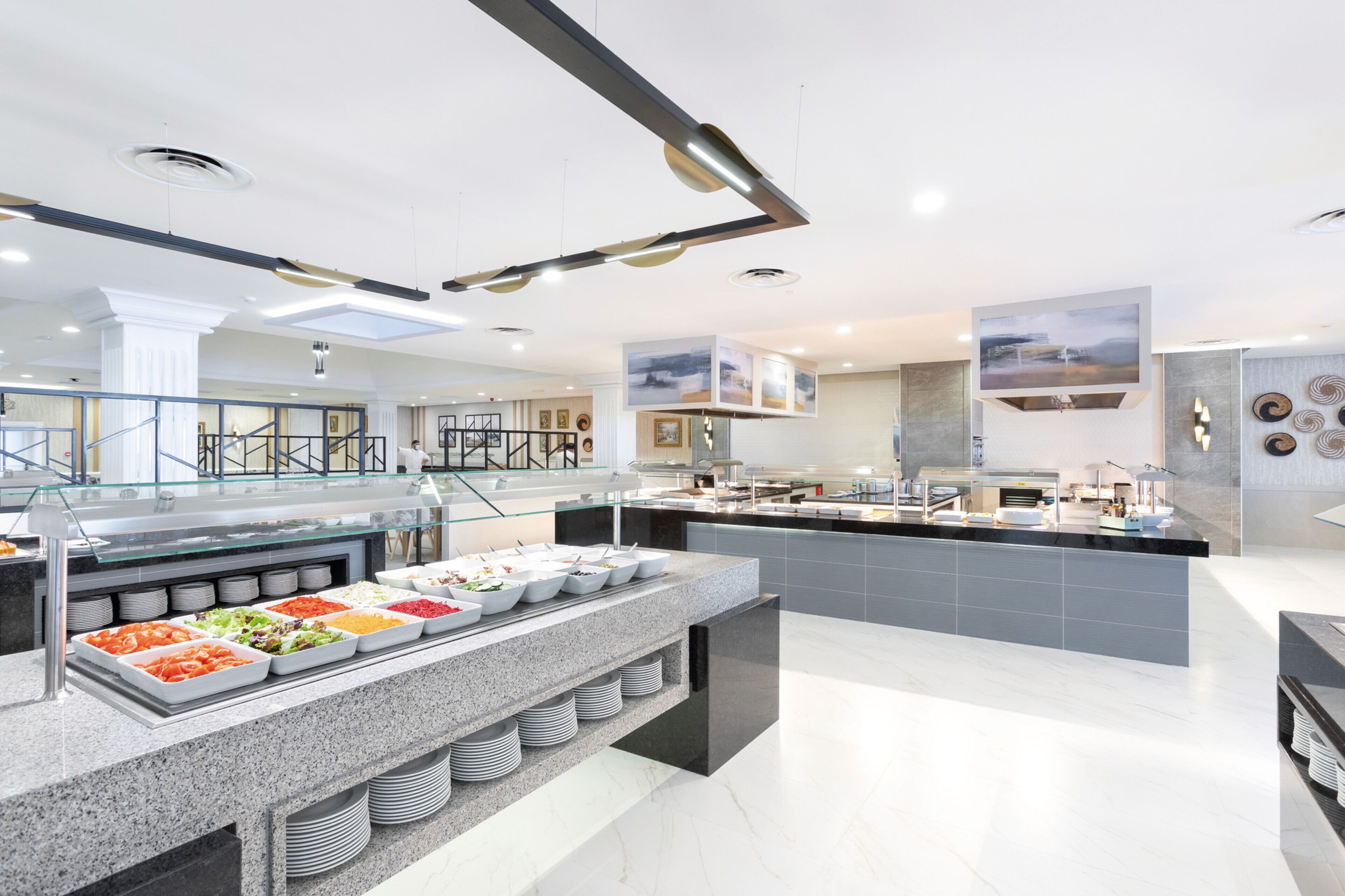 A modern hotel kitchen with a buffet area, stainless steel appliances, and a clean, contemporary design.