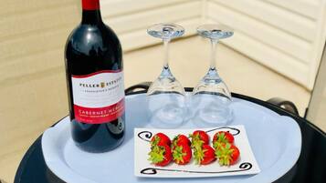Une bouteille de Peller Estates Proprietor's Reserve Cabernet Merlot, deux verres à vin vides et une assiette de fraises sur une table.