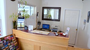 A reception desk with a computer, a map, and a plant. - Country View Motor Inn (Kamloops)
