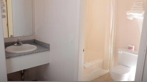A bathroom with a sink, mirror, toilet, and shower. - Country View Motor Inn (Kamloops)