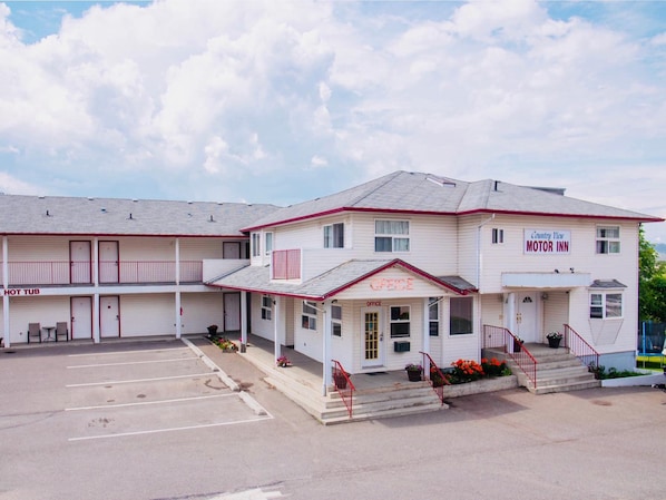 A motel with a two-story structure, a parking lot, and a sign indicating a motor inn.
