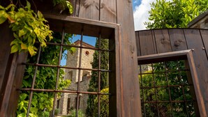 A wooden structure with a window revealing a stone building with a tower. - Hotel Villa Venus (Atena Lucana)