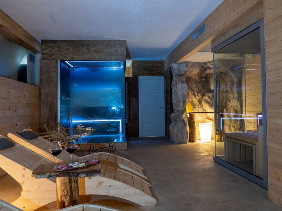 Un interno moderno con parete in vetro, arredamento in legno e parete d'accento in pietra.