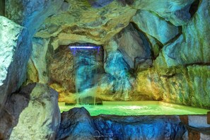 A cave-like interior with a waterfall feature and a pool. - Hotel Villa Venus (Atena Lucana)