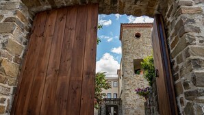 A stone building with a wooden door and a tower. - Hotel Villa Venus (Atena Lucana)