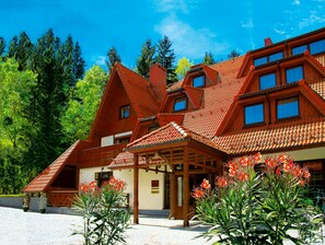 A traditional wooden building with a sloped roof, a wooden porch, and a sign that reads "Reception". - Hotel Relaks Wellness & SPA (Karpacz)