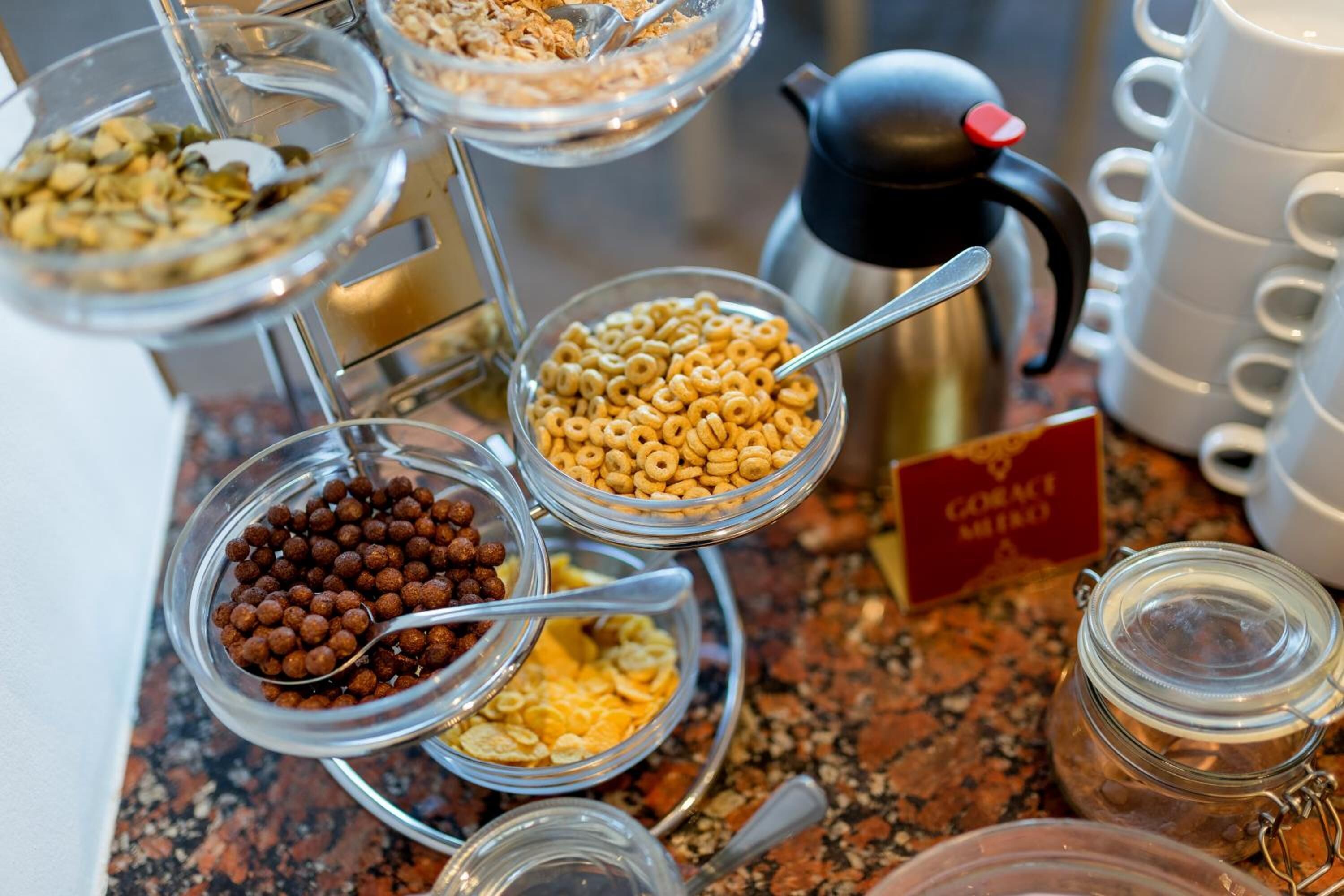 Ein Buffet mit verschiedenen Speisen, darunter Müsli, Nüsse und Trockenfrüchte.