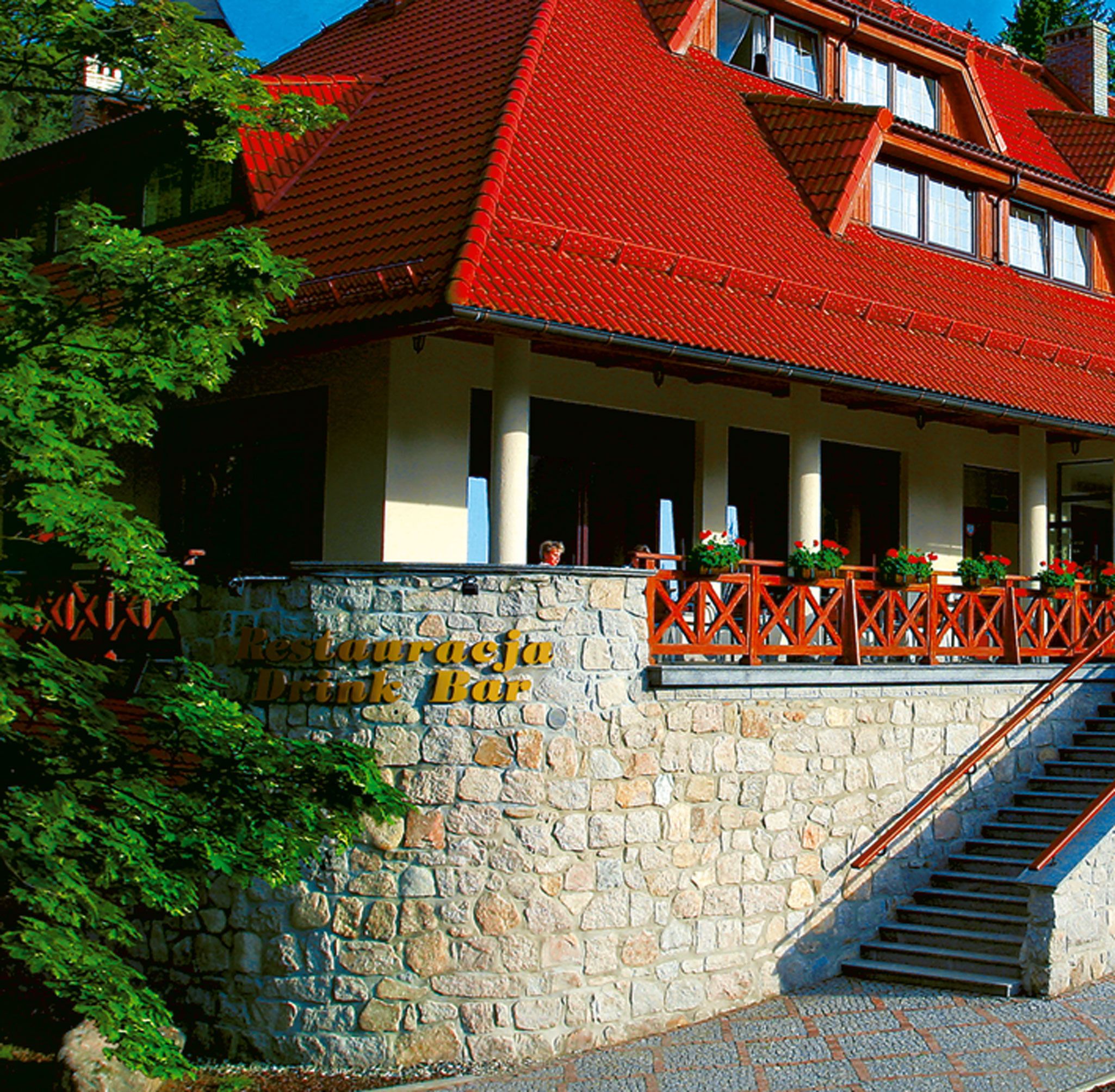 A stone wall with a sign reading "Restaurante ja Drink Bar".