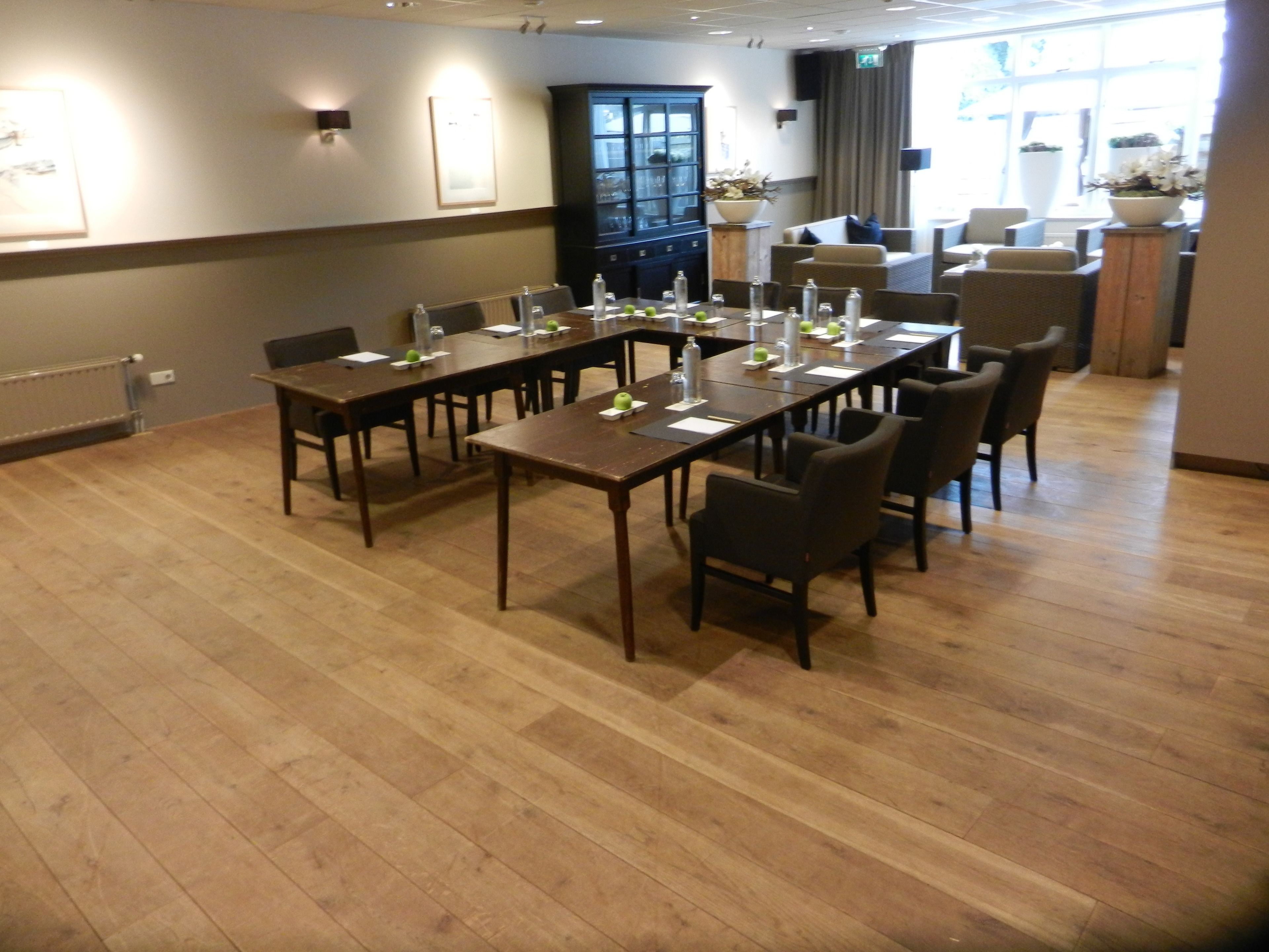 A conference room with a long table, chairs, and a cabinet.