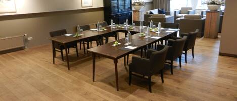 A conference room with a long table, chairs, and a cabinet.