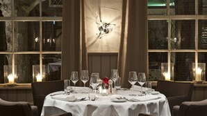 A dining area with a round table set for six, surrounded by chairs. - De Klomp - Charme Hotel & Restaurant (Vilsteren)