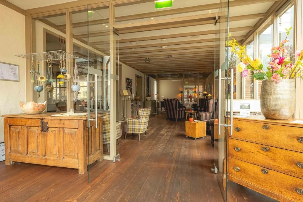 Ein modernes Interieur mit einem Holzkabinett, einer Glastausche und einer Vase mit Blumen.