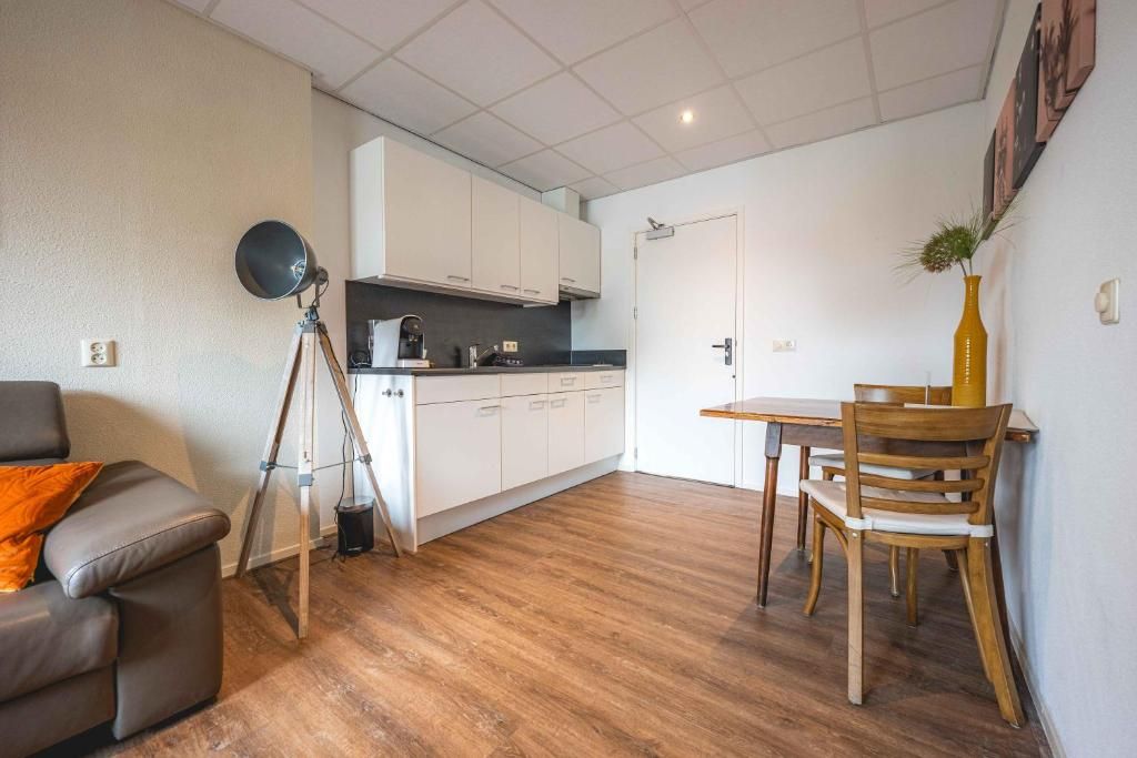 A compact living space with a kitchenette, a dining area, and a seating area.