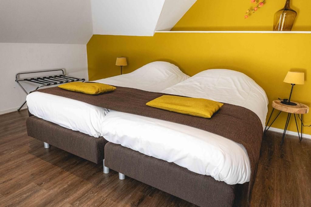 A modern bedroom with a bed, a bedside table with a lamp, and a wall-mounted shelf with flowers.