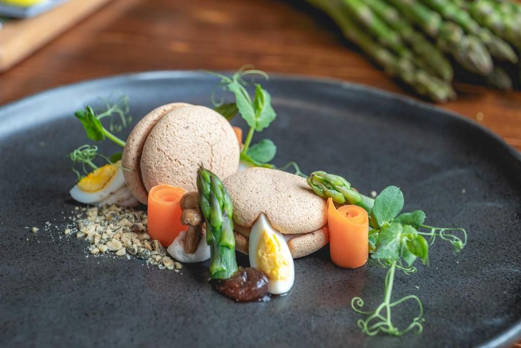 A plate with food items including mushrooms, asparagus, and a halved egg.