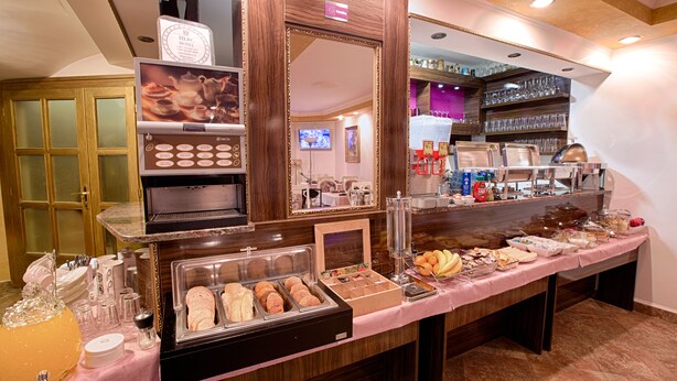 A buffet setup with various food items and a coffee machine. - Hotel Herc (Sarajevo)