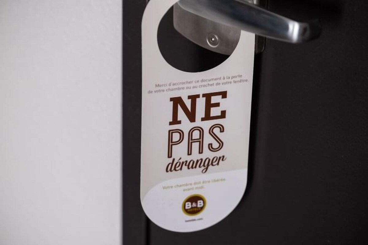 A door with a sign that reads 'NE PAS déranger' and a B&B logo.