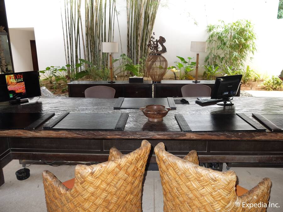 A dining area with a long table, chairs, and a television displaying an advertisement.
