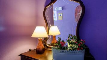 A wooden dresser with two lamps and a mirror.