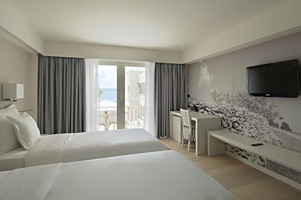 Double Room, Balcony, Partial Sea View | Minibar, in-room safe, desk, blackout drapes